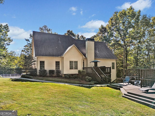 rear view of property with a deck and a yard