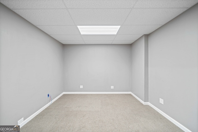 unfurnished room featuring carpet floors and a drop ceiling