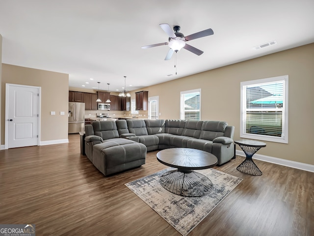 living room featuring dark wood-type flooring and ceiling fan