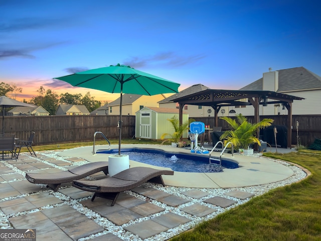 pool at dusk with a shed and a patio area