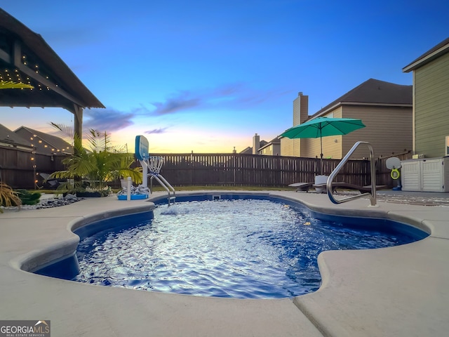 pool at dusk with a patio area