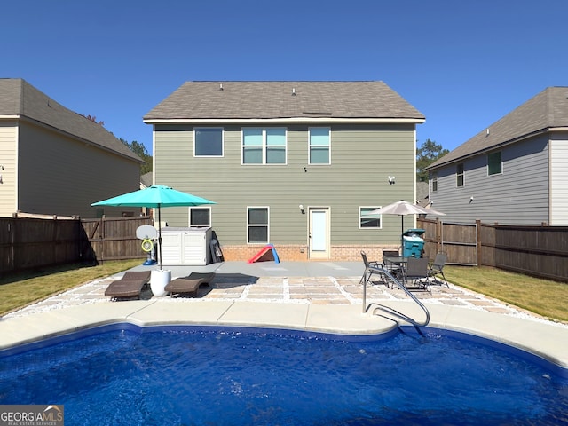 rear view of property featuring a patio area and a lawn