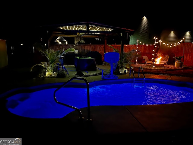 pool at twilight featuring a patio and a gazebo