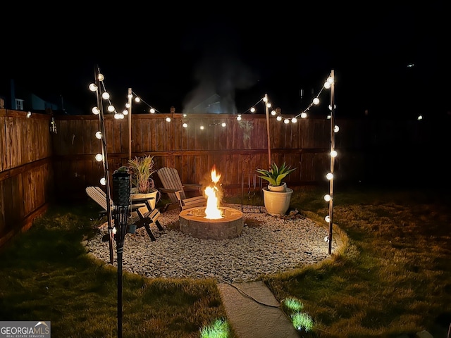 patio at twilight with an outdoor fire pit and a lawn