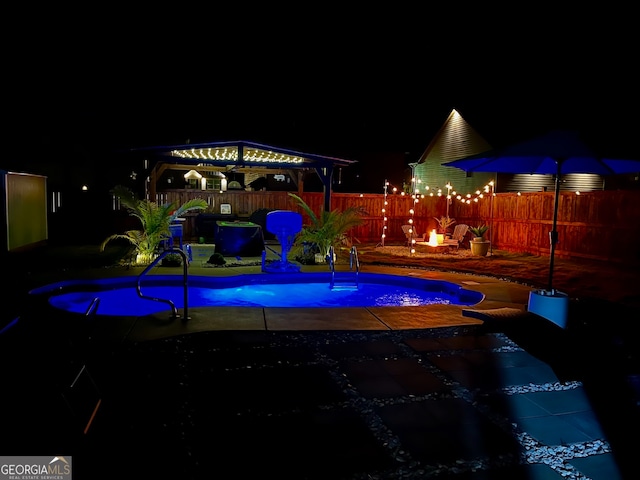 pool at night with a gazebo and a patio