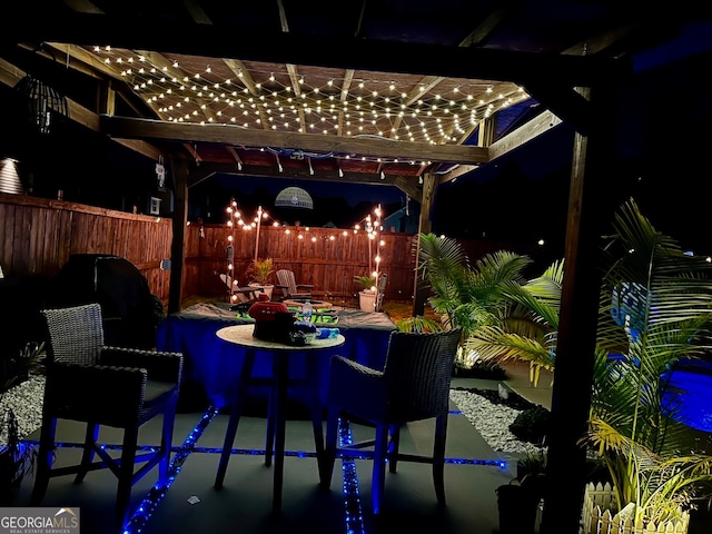 patio at night featuring a pergola