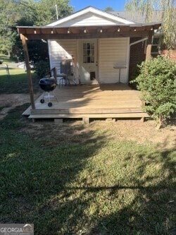 rear view of house with a deck and a yard