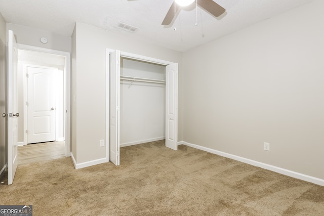 unfurnished bedroom featuring a closet, ceiling fan, and light carpet