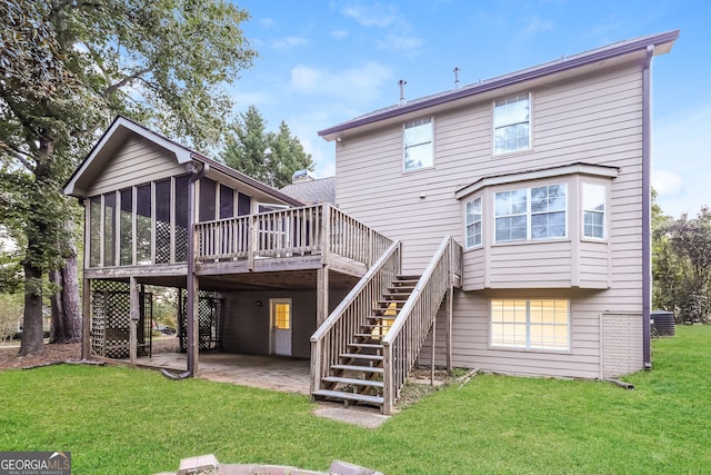 rear view of property featuring a yard, a deck, a patio, and a sunroom