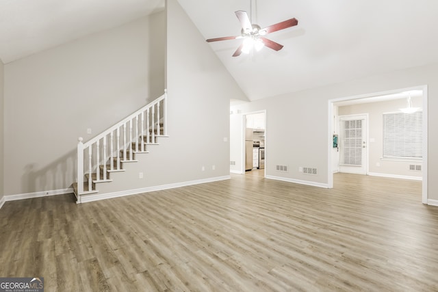 unfurnished living room with hardwood / wood-style floors, high vaulted ceiling, and ceiling fan