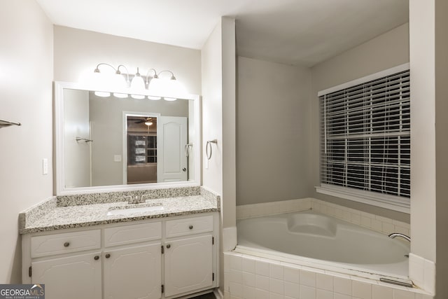 bathroom featuring vanity and a relaxing tiled tub