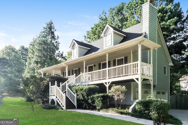 view of front of house with a front lawn, covered porch, and a garage