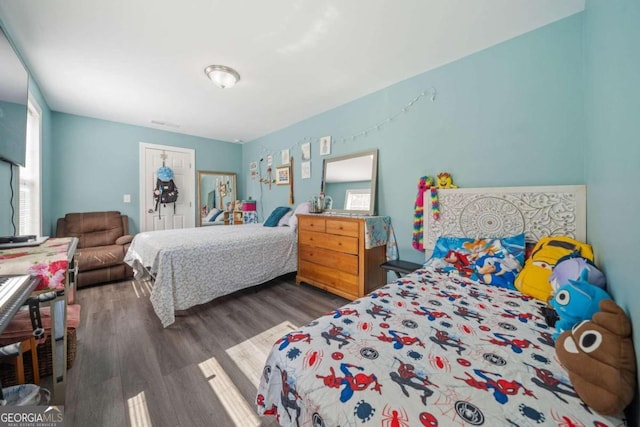 bedroom featuring multiple windows and dark hardwood / wood-style floors