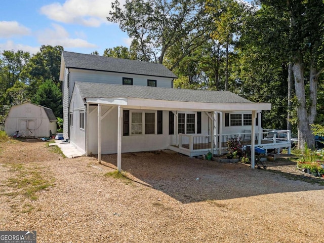 view of front of property with covered porch and a shed