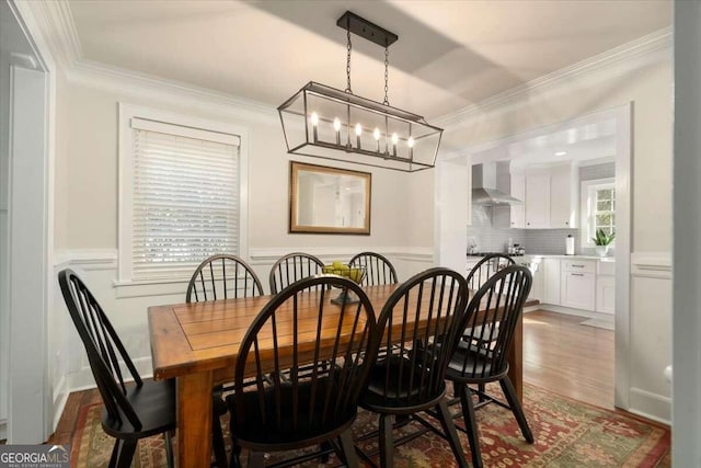 dining room with a notable chandelier, ornamental molding, and dark hardwood / wood-style flooring