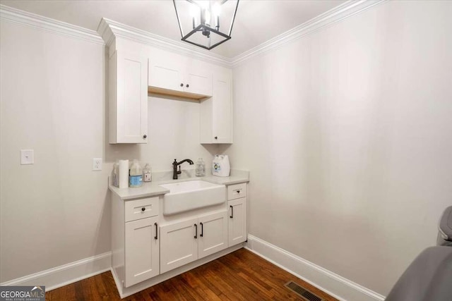 kitchen with sink, ornamental molding, dark hardwood / wood-style flooring, and white cabinets