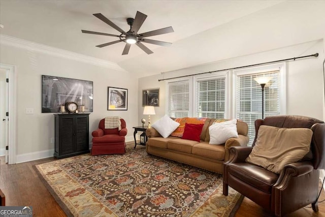 living area featuring lofted ceiling, wood finished floors, ornamental molding, baseboards, and ceiling fan