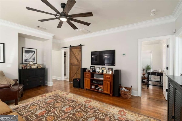 living area featuring a barn door, wood finished floors, ceiling fan, ornamental molding, and visible vents