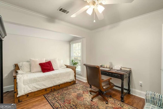 bedroom featuring ceiling fan, crown molding, and wood-type flooring