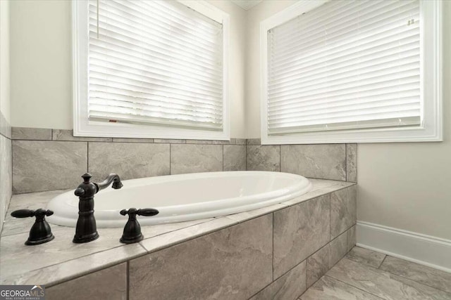 bathroom featuring a healthy amount of sunlight and tiled bath