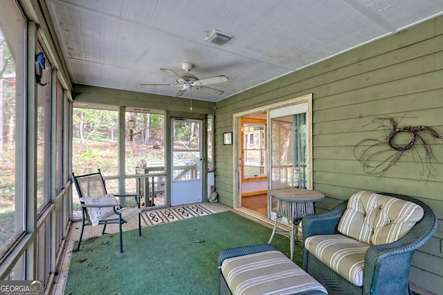 unfurnished sunroom featuring ceiling fan