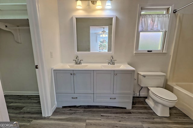 full bathroom with a wealth of natural light, tub / shower combination, vanity, and toilet