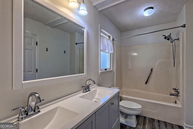 full bathroom featuring toilet, wood-type flooring, vanity, washtub / shower combination, and a textured ceiling