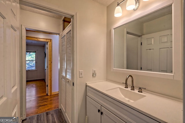 bathroom featuring vanity, hardwood / wood-style flooring, and a textured ceiling