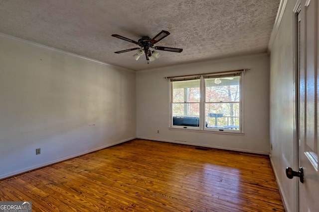 empty room featuring ornamental molding, hardwood / wood-style floors, a textured ceiling, and ceiling fan