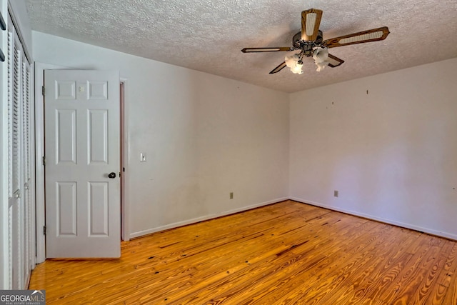 unfurnished room featuring light hardwood / wood-style floors, a textured ceiling, and ceiling fan