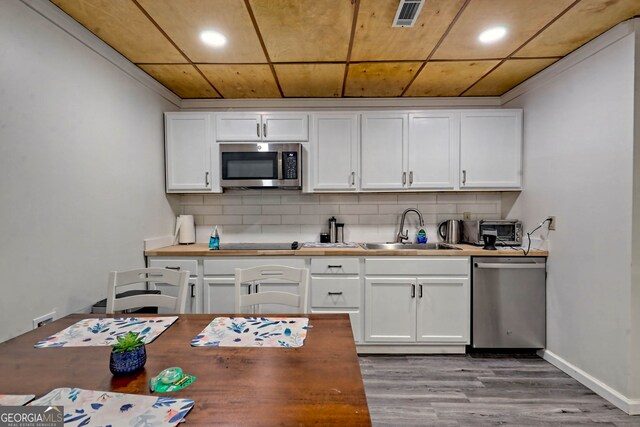 kitchen with sink, backsplash, light hardwood / wood-style floors, stainless steel appliances, and white cabinets