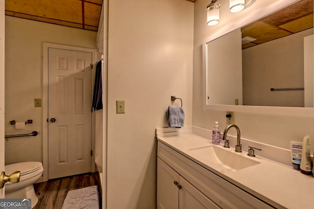 bathroom featuring toilet, hardwood / wood-style floors, and vanity