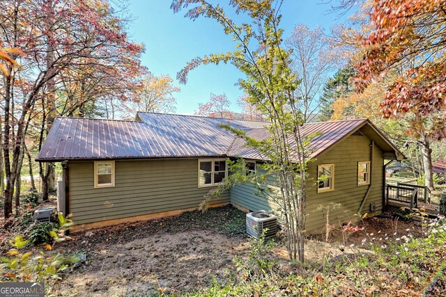 back of house with central AC and a wooden deck