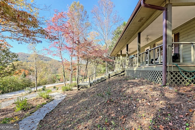 view of yard with a mountain view and ceiling fan