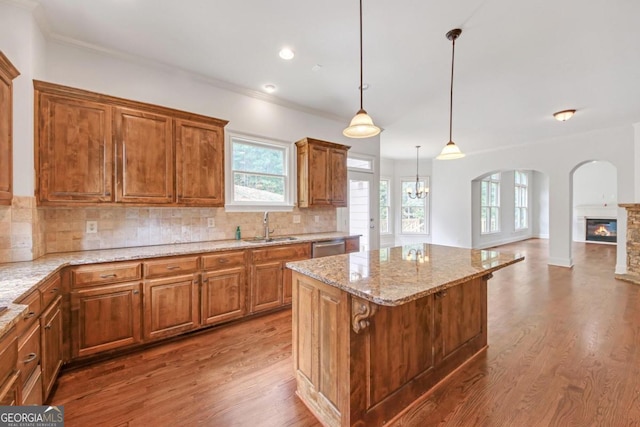 kitchen featuring pendant lighting, a center island, sink, and backsplash