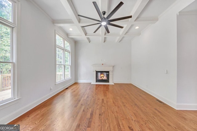 unfurnished living room featuring ornamental molding, coffered ceiling, ceiling fan, wood-type flooring, and beamed ceiling