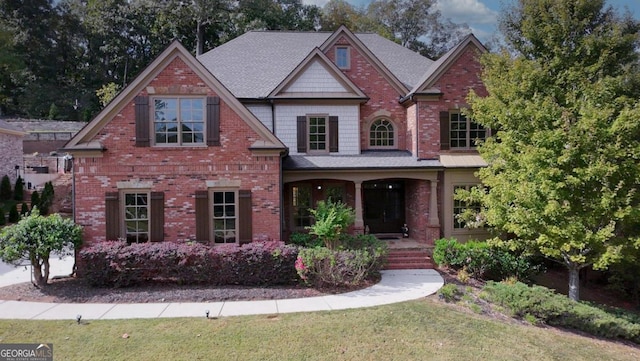 craftsman-style house with a front lawn and covered porch