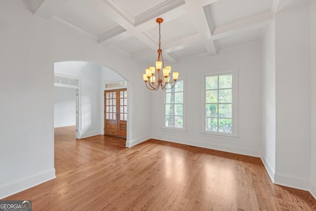 spare room featuring french doors, coffered ceiling, hardwood / wood-style flooring, an inviting chandelier, and beamed ceiling