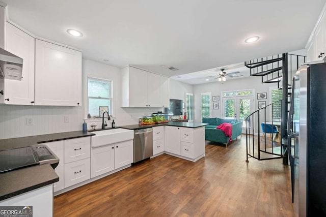 kitchen with appliances with stainless steel finishes, white cabinetry, french doors, and kitchen peninsula