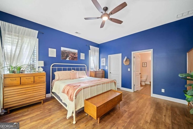 bedroom with ensuite bath, ceiling fan, and hardwood / wood-style floors