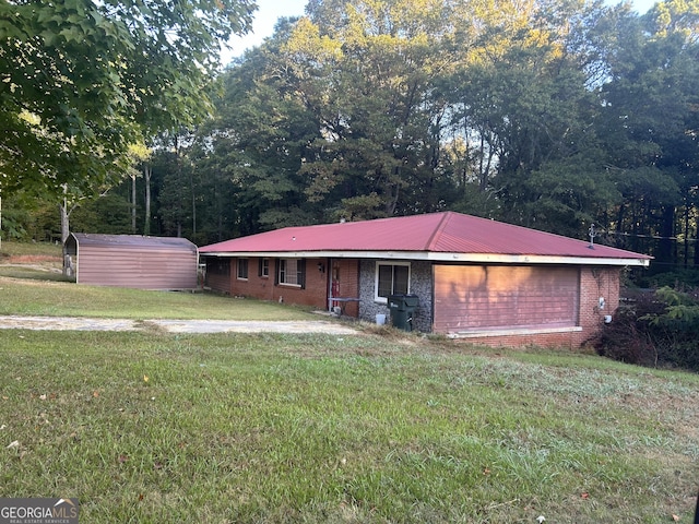 single story home featuring metal roof, a front lawn, and brick siding