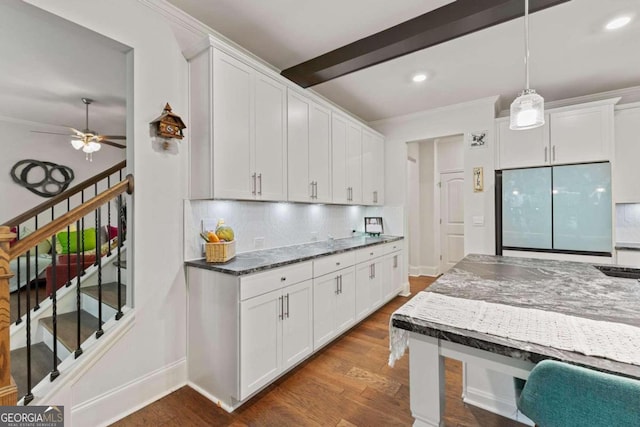 kitchen with decorative backsplash, wood-type flooring, decorative light fixtures, white cabinets, and stainless steel refrigerator