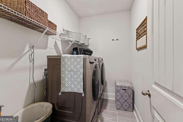 laundry area with washing machine and dryer and light tile patterned floors