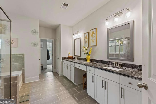 bathroom with vanity, walk in shower, and plenty of natural light