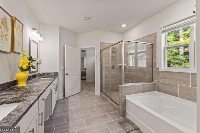 bathroom featuring vanity and independent shower and bath