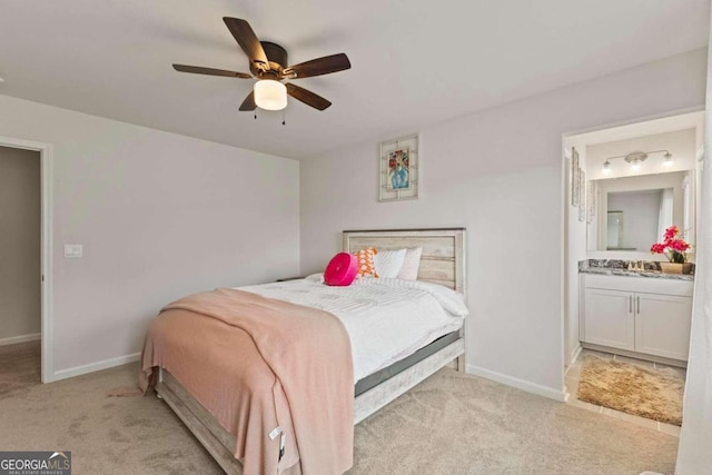 bedroom featuring light colored carpet, connected bathroom, and ceiling fan