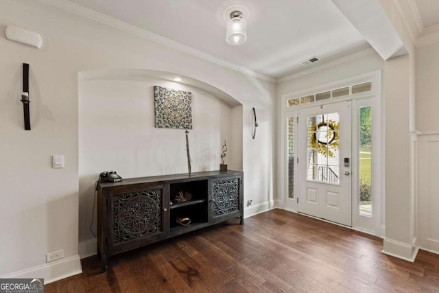 foyer with ornamental molding and dark hardwood / wood-style floors