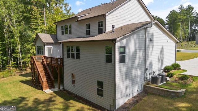 back of house featuring a deck, a yard, and central AC unit