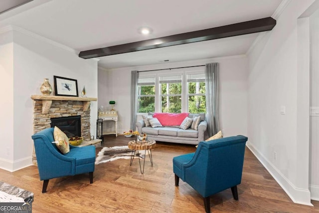 living room featuring crown molding, beamed ceiling, a fireplace, and hardwood / wood-style floors