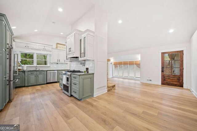 kitchen featuring light hardwood / wood-style flooring, vaulted ceiling, white cabinetry, and a healthy amount of sunlight